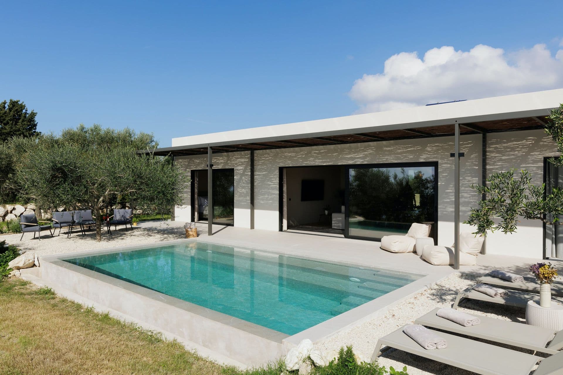 Modern villa with an infinity pool and loungers among olive trees at Corfu Dreams, Corfu